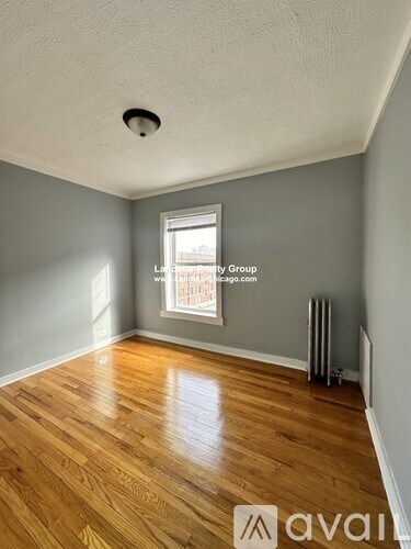 A room with wooden flooring and a window.