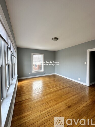A room with wooden flooring and a window.