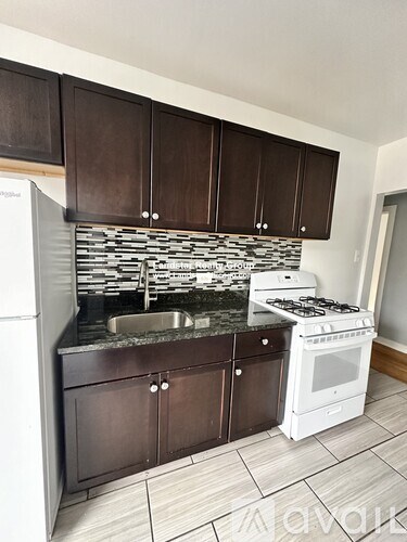 A kitchen with white appliances and brown cabinets.
