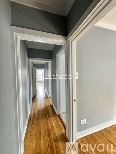 A long hallway with wooden floors and white walls.