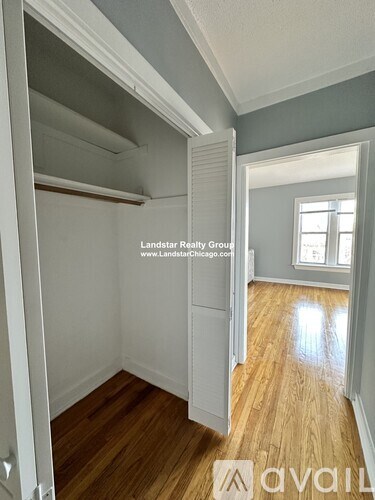 A room with wooden floors and a white door is shown.