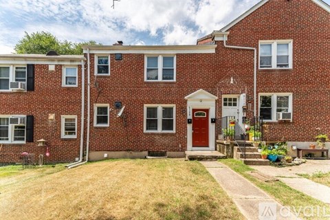 A red brick house with a white door and windows.