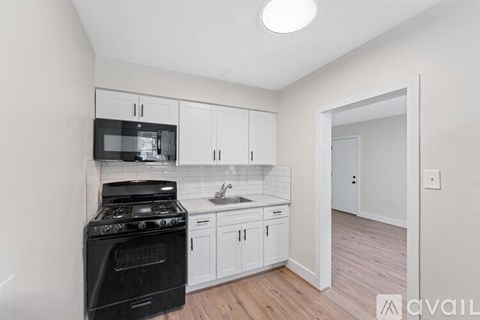 A kitchen with white cabinets and a black stove top oven.
