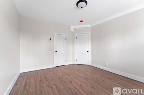 A room with two doors and a camera on the ceiling.