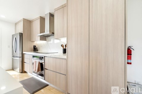 A kitchen with wooden cabinets and a stainless steel refrigerator.