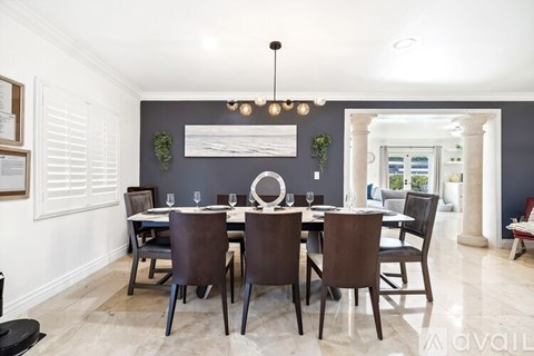 A dining room with a table set for six.