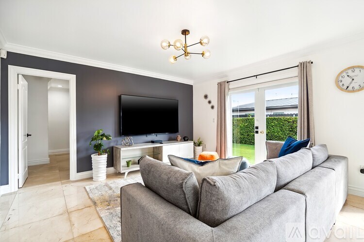 A living room with a grey couch and a television.