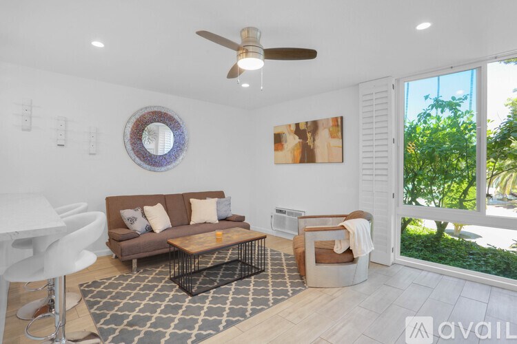 A living room with a brown couch and a white chair.