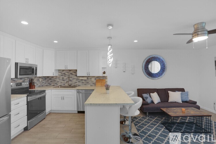 A kitchen with a white fridge, stove, and microwave.