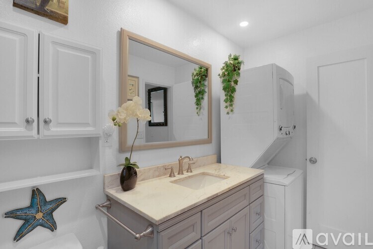 A bathroom with a sink, mirror, and a starfish decoration.