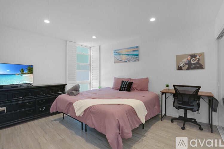 A bedroom with a bed, desk, and chair.