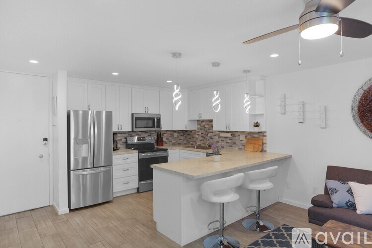 A modern kitchen with white cabinets and stainless steel appliances.