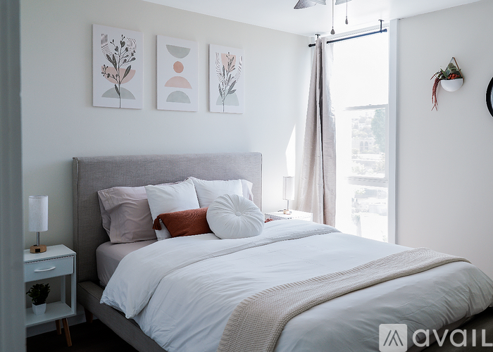 A bedroom with a large bed and a small nightstand with a lamp.