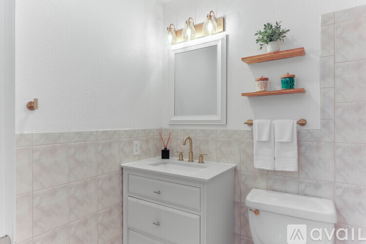 A bathroom with a white vanity and a white toilet.