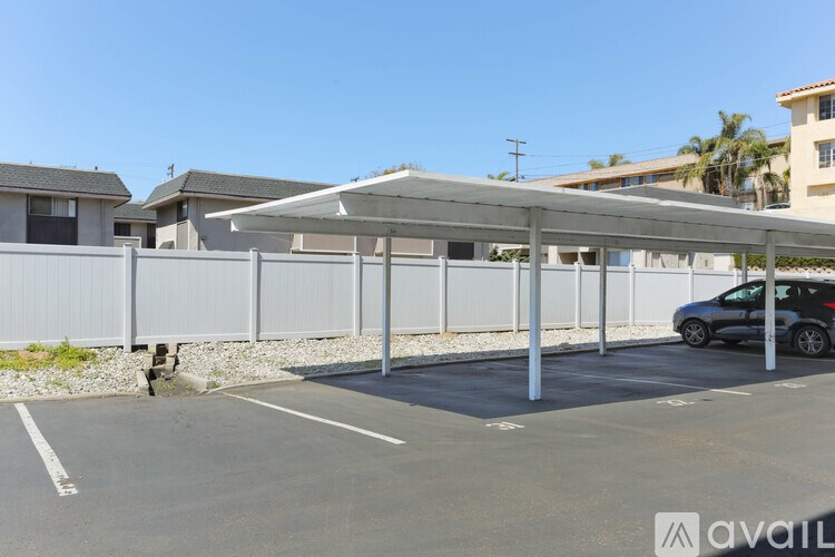 A parking lot with a car parked under a canopy.