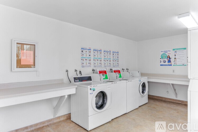 A laundry room with washers and dryers and a calendar on the wall.