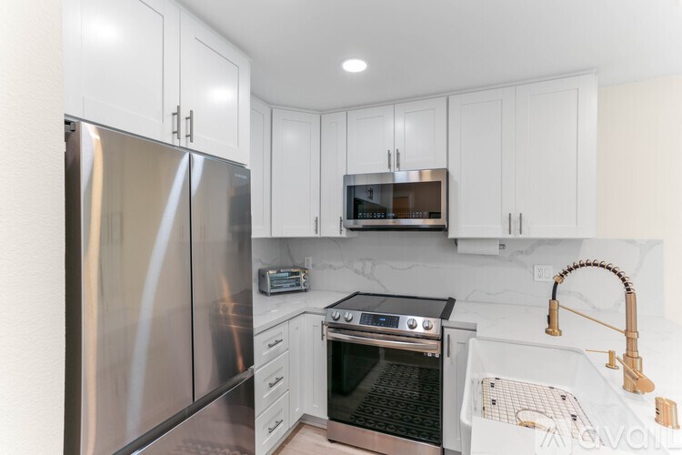 A modern kitchen with stainless steel appliances and white cabinets.