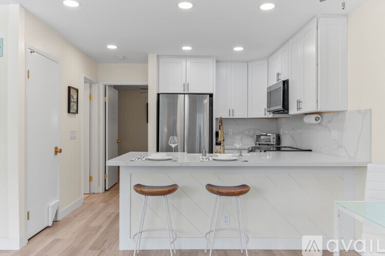 A kitchen with white cabinets and a white countertop.