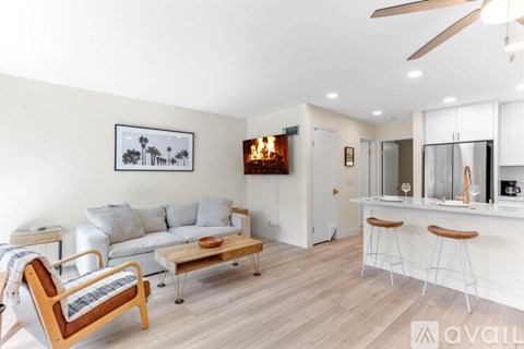 A living room with a white couch and a wooden chair.