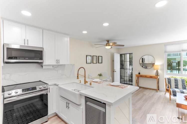 A modern kitchen with white cabinets and a marble countertop.