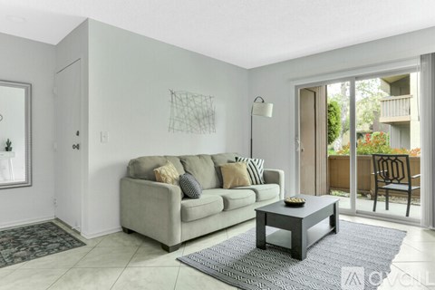 A living room with a grey couch and a coffee table.