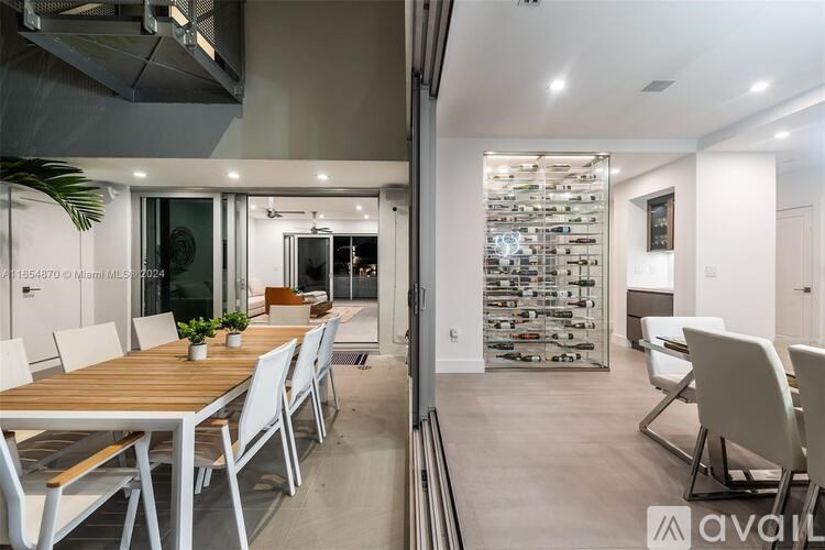 A modern dining area with a wooden table and white chairs.