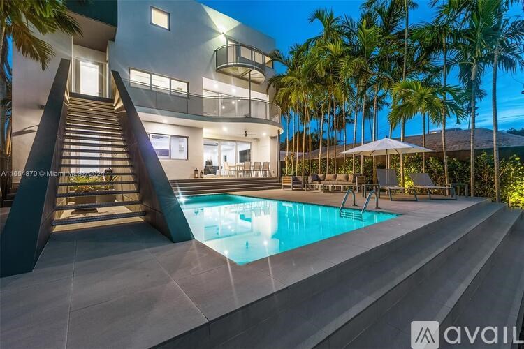 A modern house with a pool and palm trees in the background.