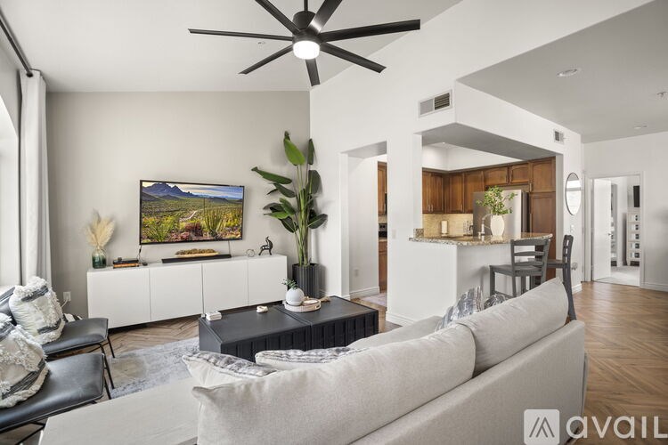 A living room with a white couch and a ceiling fan.