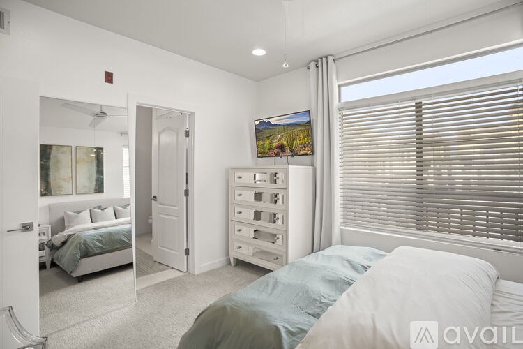 A bedroom with a bed, dresser, and television.