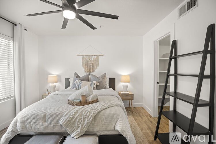 A bedroom with a large bed and a ceiling fan.
