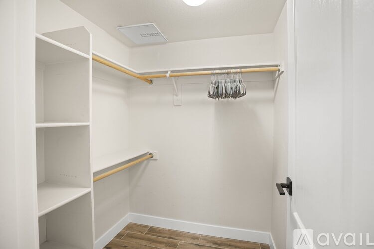 A small white closet with a coat hanger.