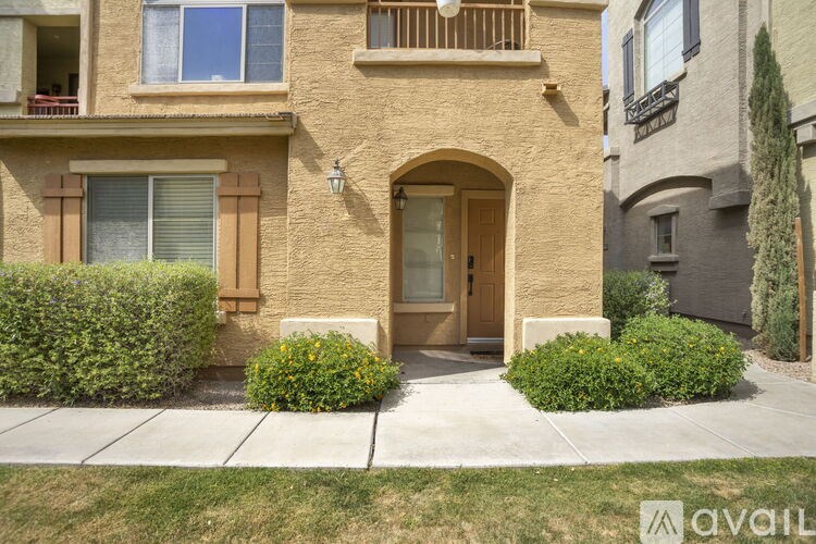 A beige house with a brown door and windows.