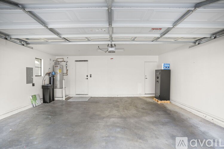 A large, empty garage with a concrete floor and white walls.