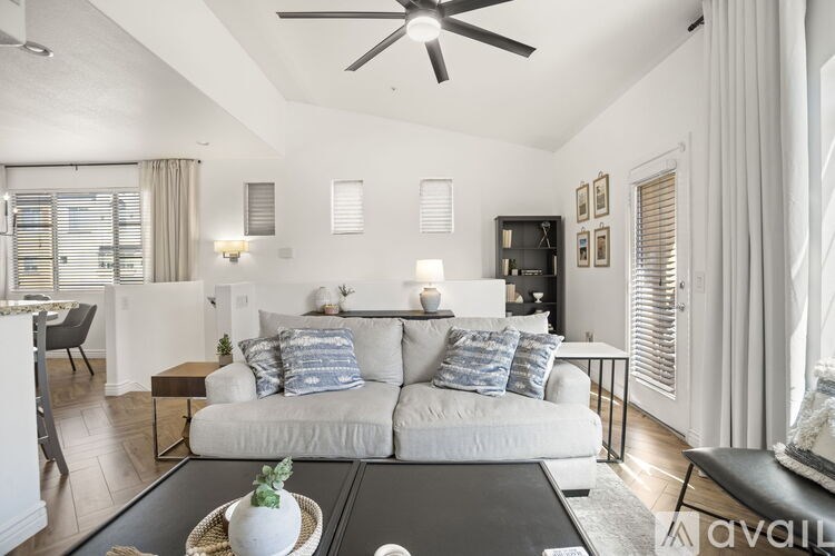 A living room with a white sofa and a black coffee table.