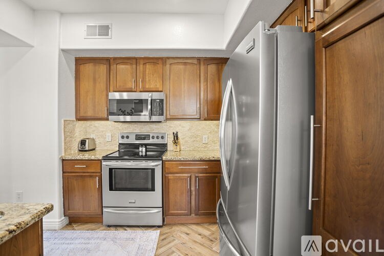 A kitchen with a refrigerator, oven, microwave, and cabinets.