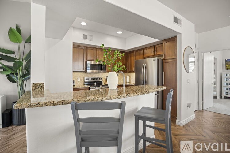 A kitchen with granite countertops and wooden cabinets.