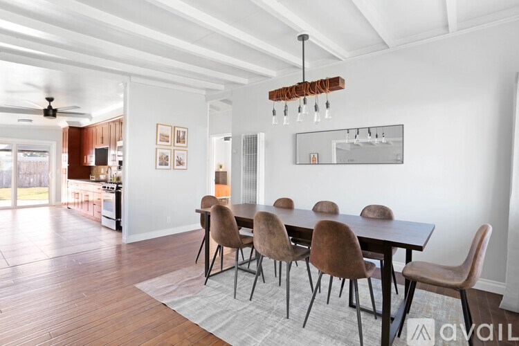 A modern dining room with a wooden table and chairs.