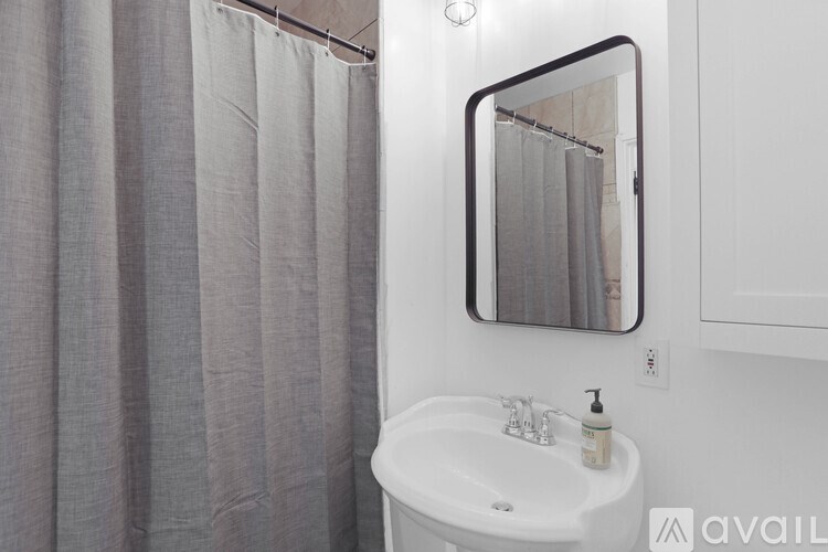 A bathroom with a white sink and a mirror.