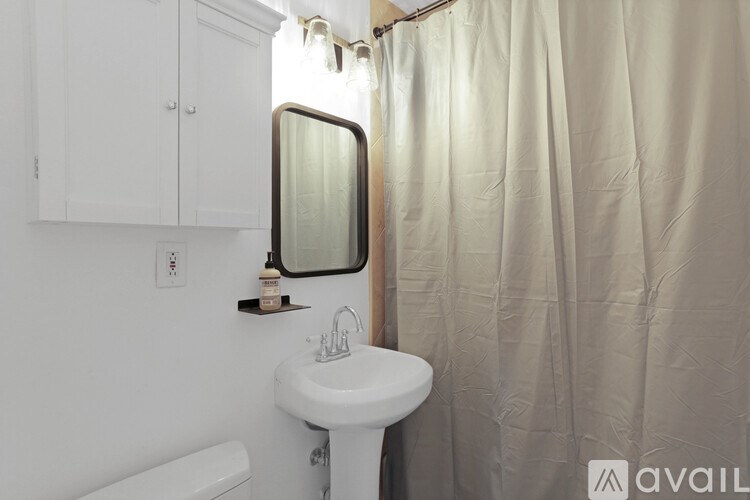 A white sink in a bathroom with a shower curtain.