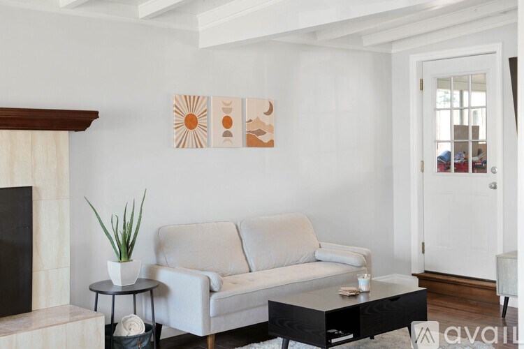A living room with a grey couch, a black coffee table, and a fireplace.