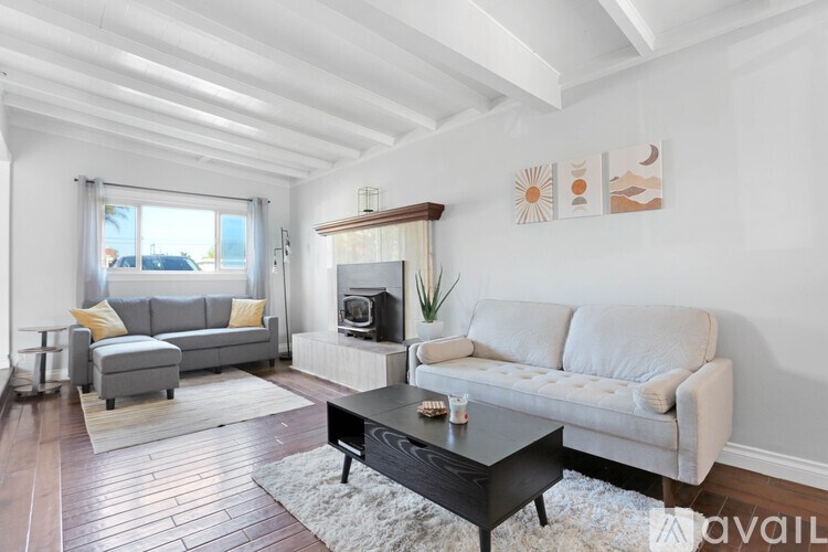 A living room with a grey sofa, a black coffee table, and a fireplace.