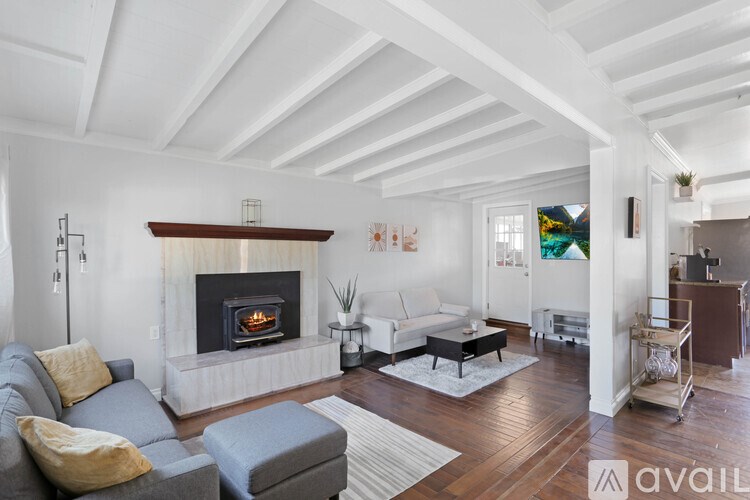 A living room with a fireplace and a grey couch.