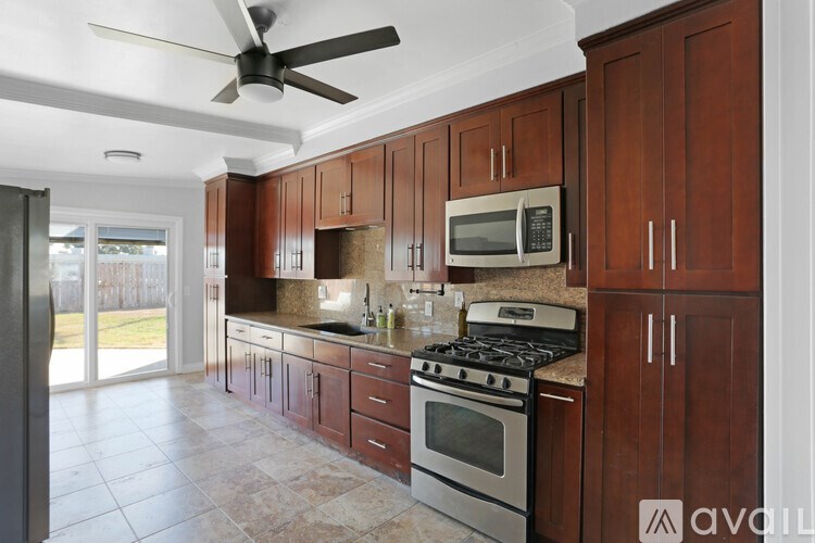 A kitchen with brown cabinets and a stove top oven.