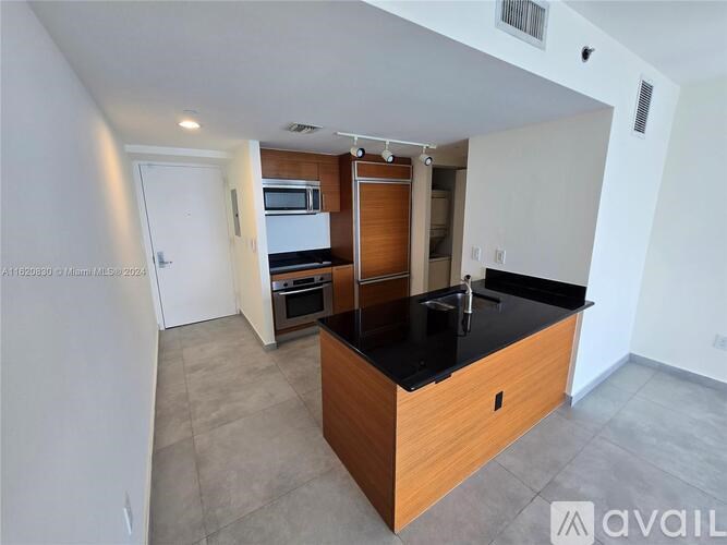 A kitchen with a black countertop and wooden cabinets.