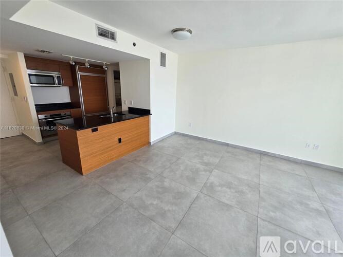 A kitchen with a wooden island and a microwave above it.