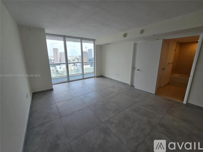 A spacious room with large windows overlooking a cityscape.