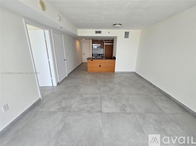 A spacious room with a grey floor and white walls.
