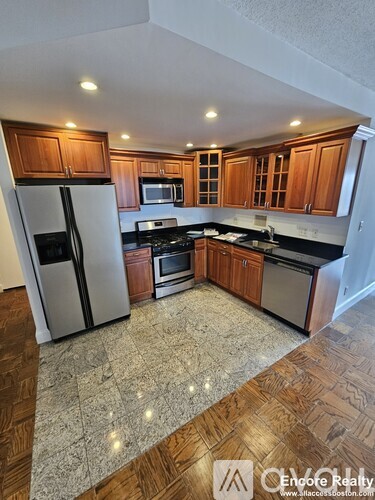 A kitchen with wooden cabinets and granite countertops.