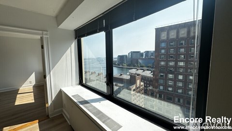 A room with a view of the city through large windows.