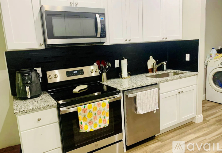 A kitchen with a black countertop and white cabinets.